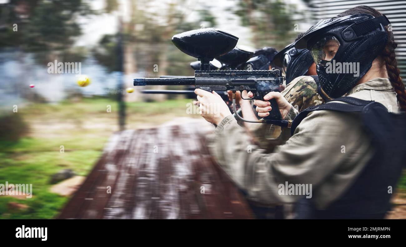 Paintball, soldato e azione con pistola per tiro, velocità e campo di battaglia militare con sport, guerra e fitness all'aperto. Persone insieme dentro Foto Stock