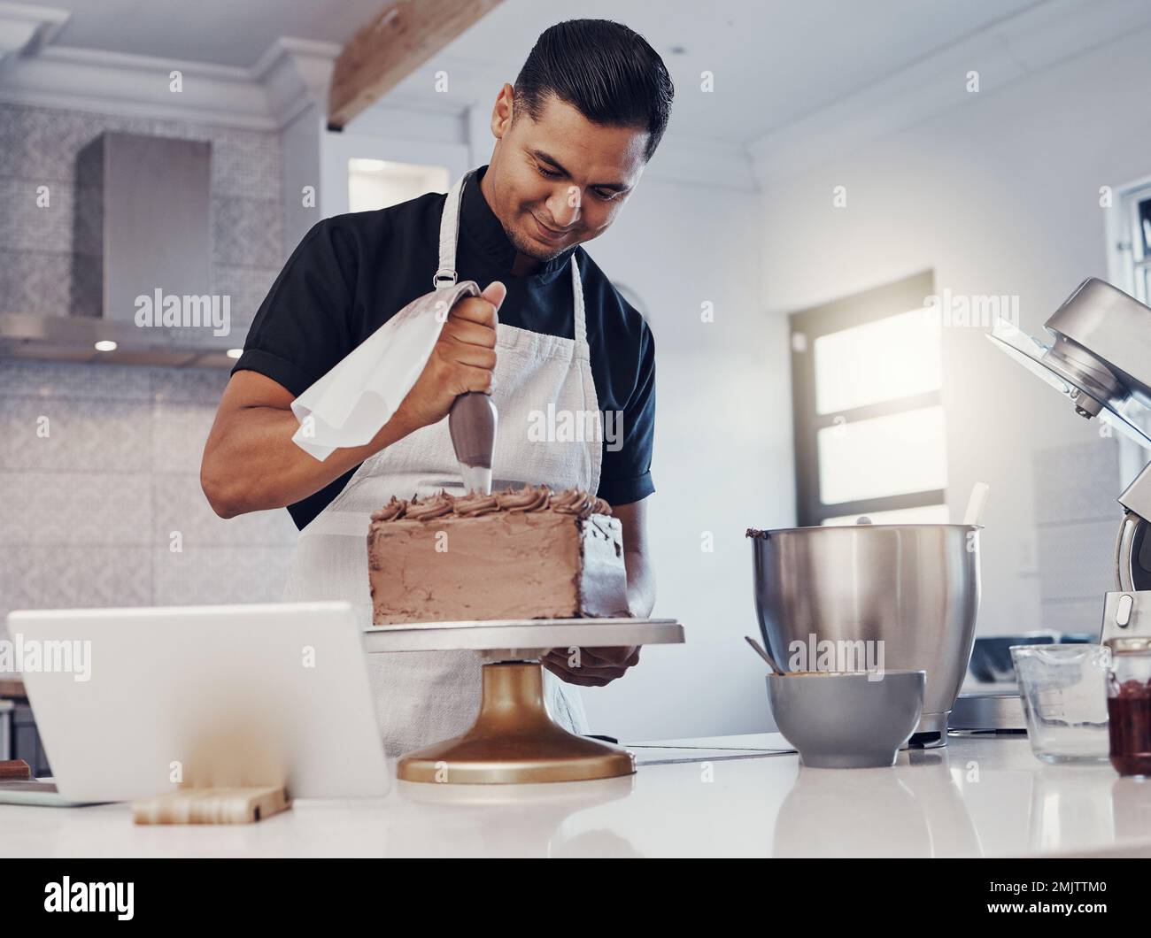 Tubatura, decorazione e cottura da parte dell'uomo di una torta al cioccolato in cucina o pasticciere felice con ricetta online. Cibo, deserto e cuoco preparare un dolce Foto Stock
