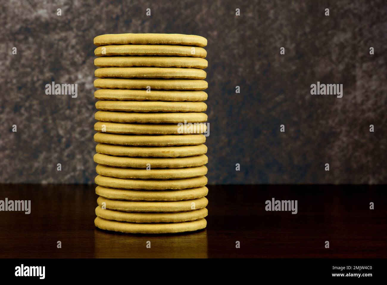 Un mucchio di biscotti semplici su una mensola di legno lucidato Foto Stock
