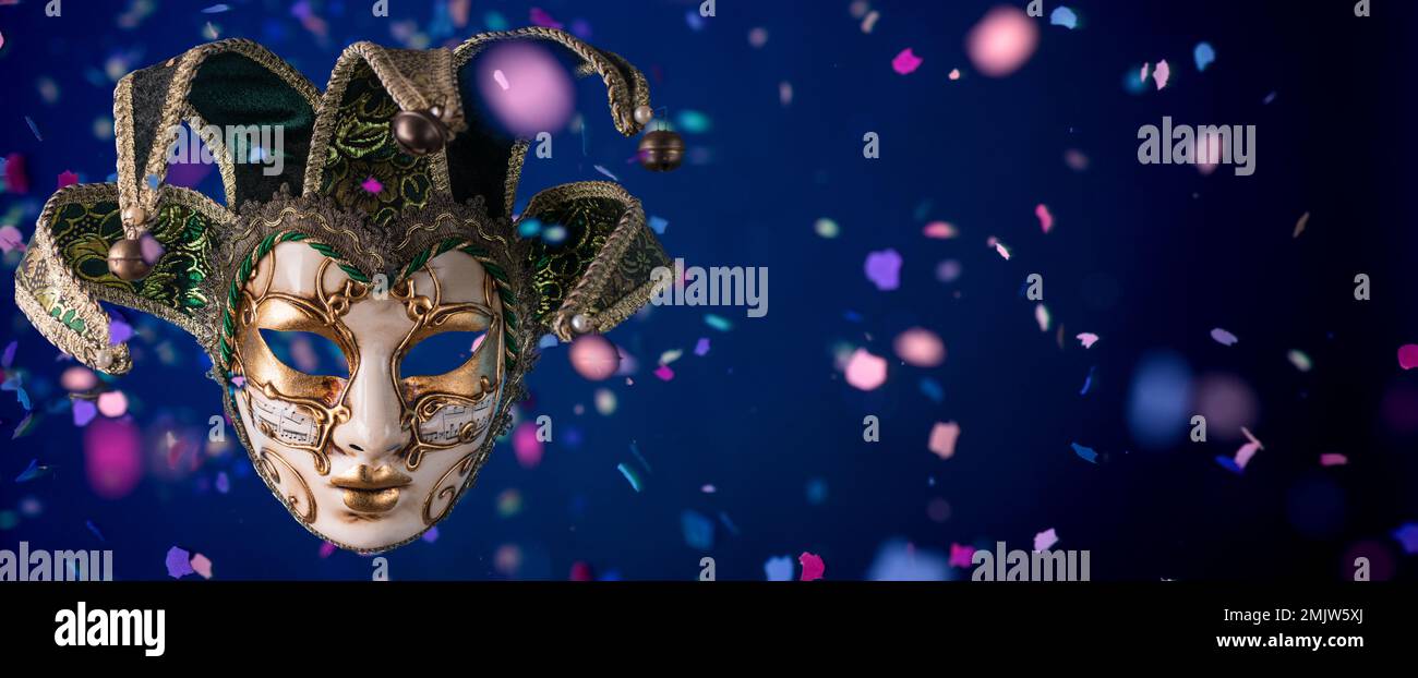 Maschera carnevale veneziana tra i confetti volanti in formato banner Foto Stock