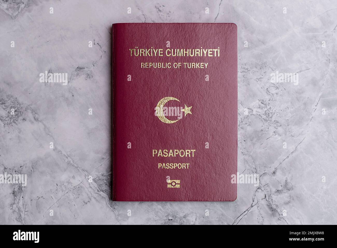 Primo piano di un passaporto turco. Documenti di viaggio e passaporti su sfondo marmoreo. Documenti e documenti relativi al visto. Immigrazione e rifugiati. Foto Stock