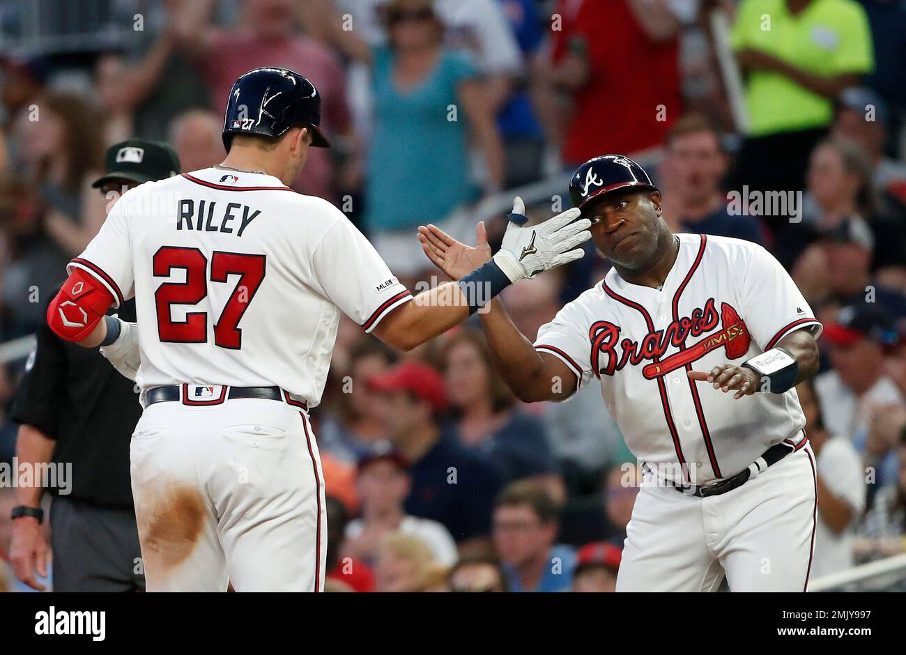 Atlanta Braves rookie Austin Riley (27) celebrates with first base coach Eric Young (2) after driving in a run with a base hit in the third inning of a baseball game against the St. Louis Cardinals Thursday, May 16, 2019, in Atlanta. (AP Photo/John Bazemore) Foto Stock