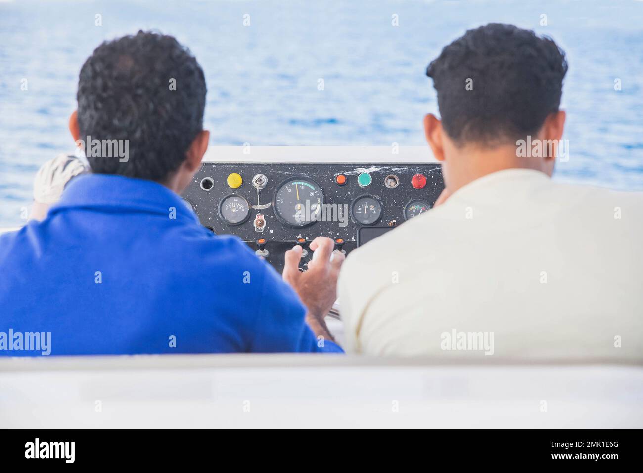 Due marinai al timone di una nave in mare Foto Stock