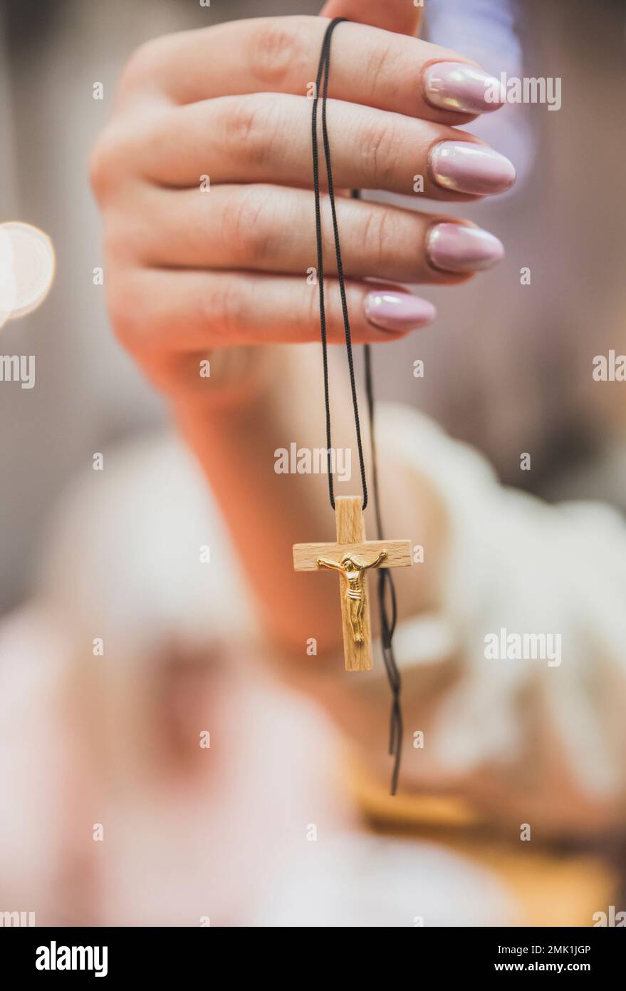 donna tenere croce di legno con crocefisso dorato in mano Foto Stock