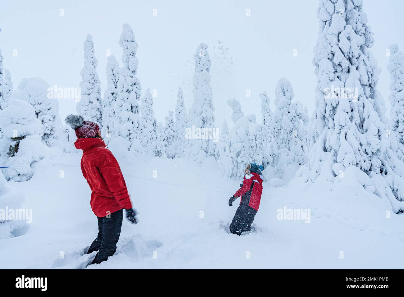 Donna allegra con figlio che si diverte giocando con la neve, Lapponia, Finlandia Foto Stock
