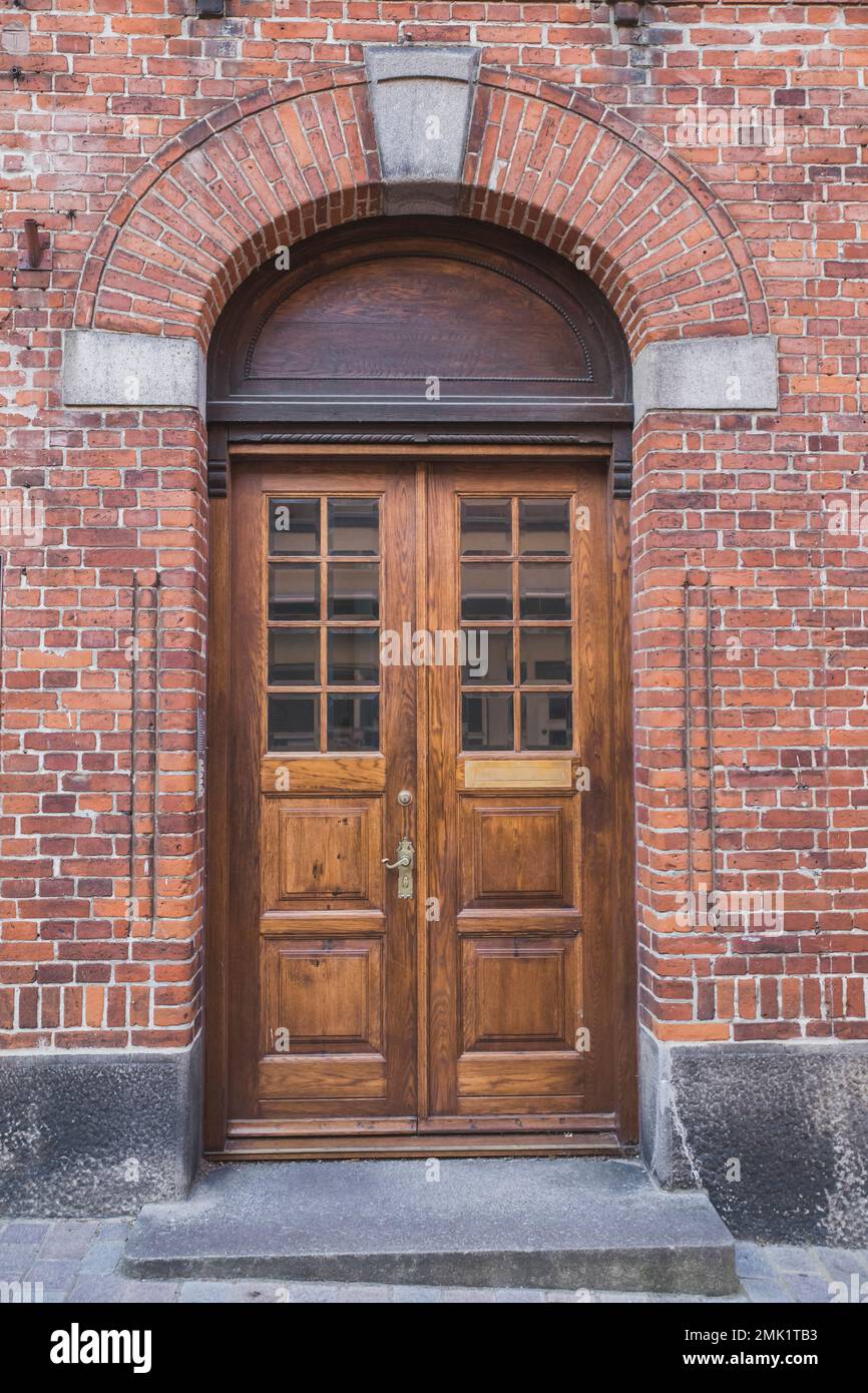 Porte in legno con arco in una vecchia casa in mattoni in Danimarca Foto Stock