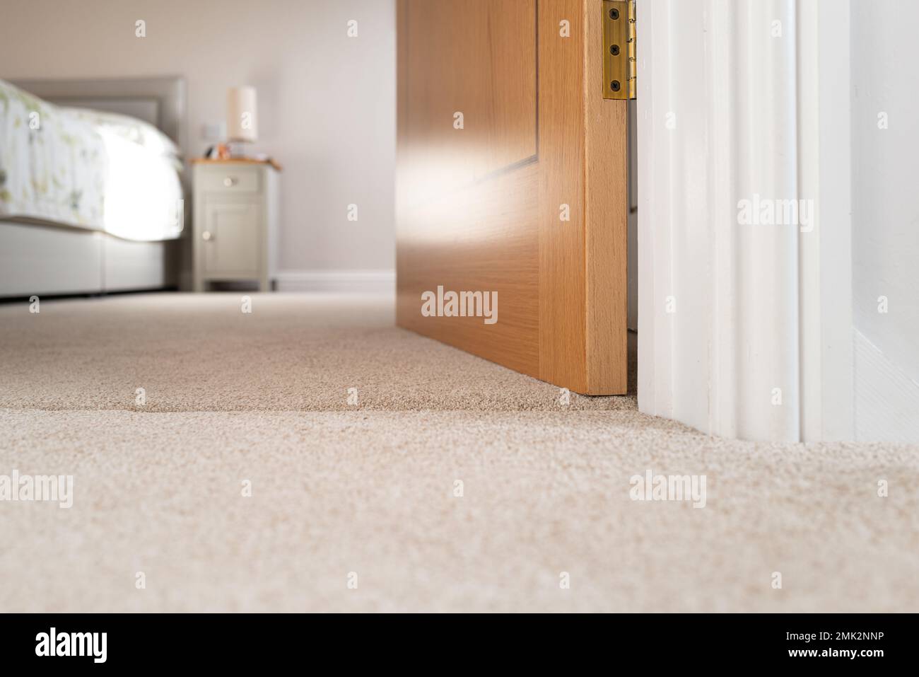 Vista a livello della superficie di una porta aperta che si estende fino ad una camera da letto al primo piano. Foto Stock