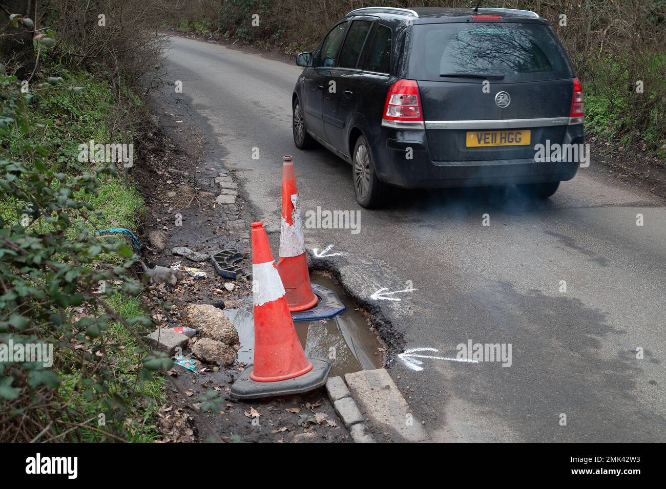 Wexham, Buckinghamshire, Regno Unito. 28th gennaio 2023. Buche su una corsia di campagna a Wexham, Buckinghamshire segnalato per la riparazione. Il Buckinghamshire Council ripara le buche, ma spesso vengono riparate solo in breve tempo, le buche ritornano causando pericolo per ciclisti e conducenti, nonché il rischio di contenziosi quando pneumatici e sospensioni sui veicoli vengono danneggiati da veicoli che guidano nelle buche. Credit: Maureen McLean/Alamy Live News Foto Stock