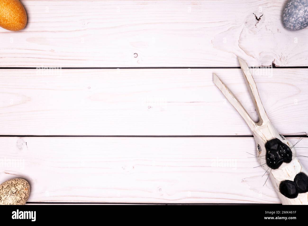 Tavolo rustico in legno bianco con uova di Pasqua di colore sottile e coniglietto di Pasqua in legno Foto Stock