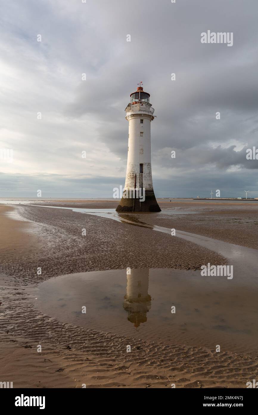 New Brighton, Regno Unito: Faro di Perch Rock riflesso nelle piscine d'acqua con la bassa marea. Un simbolo iconico sulla penisola di Wirral. Foto Stock