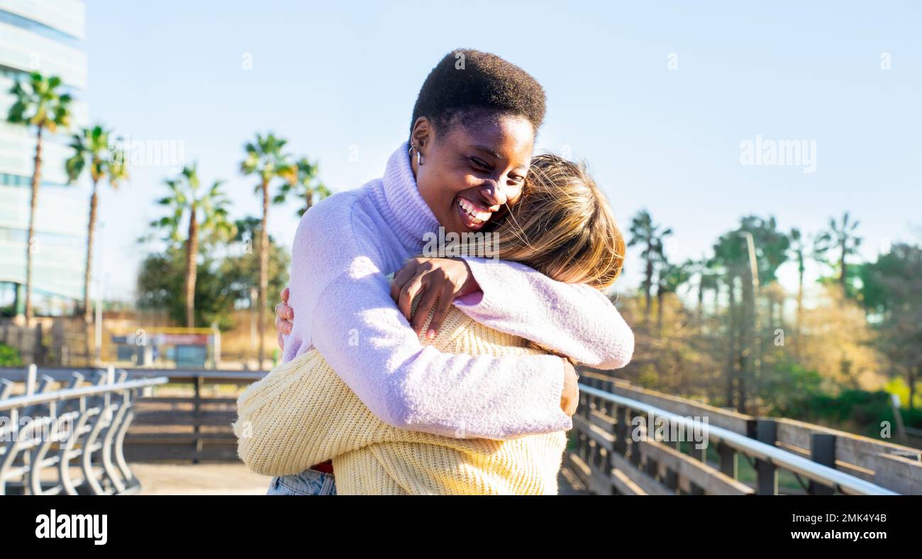 Due ragazze amici che abbracciano affettuosamente felice sorridendo. Donne che si divertono insieme e abbracciano. Foto Stock