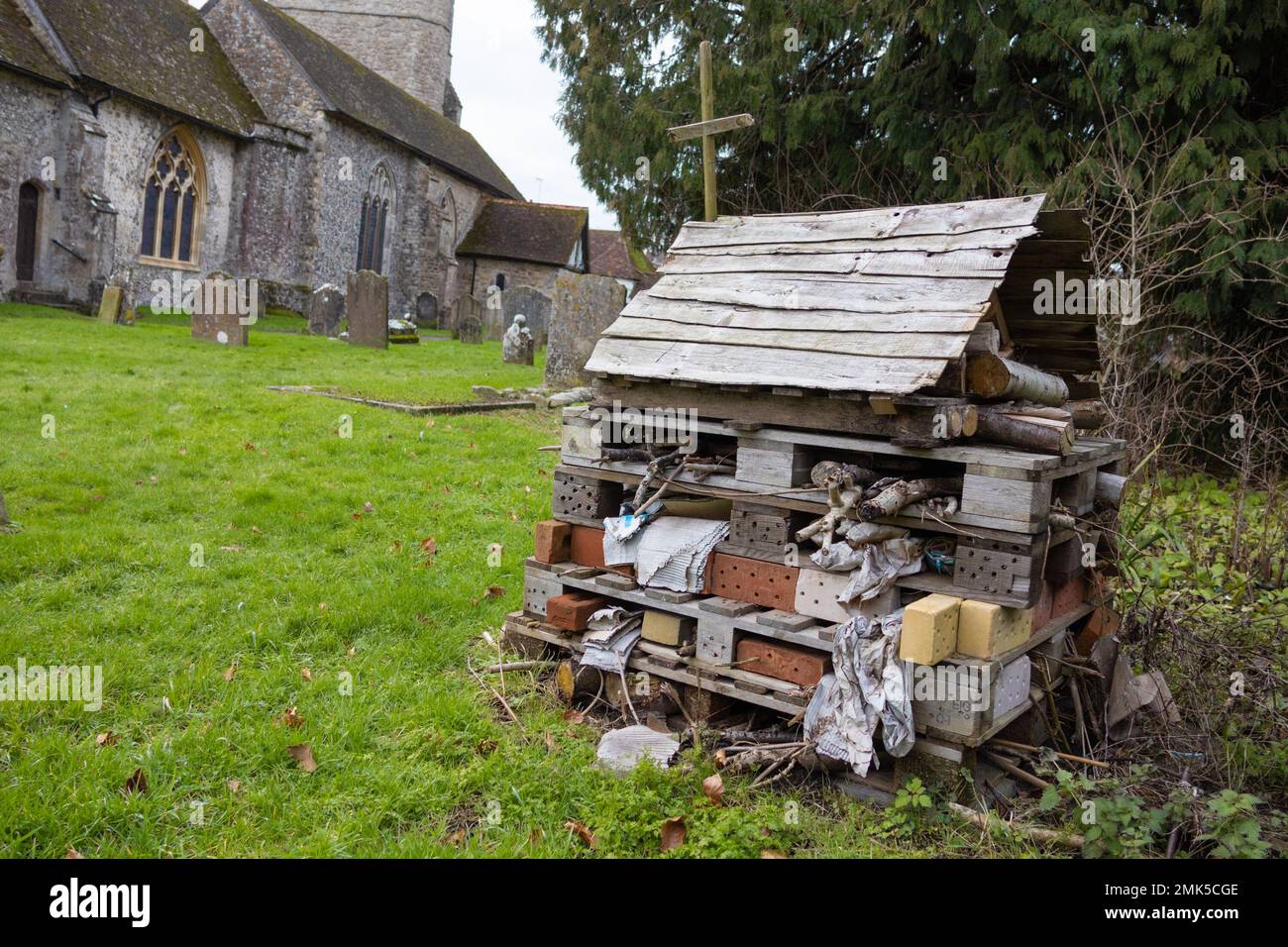 Bug insetto hotel nel terreno della chiesa con croce, lenham, kent, regno unito Foto Stock