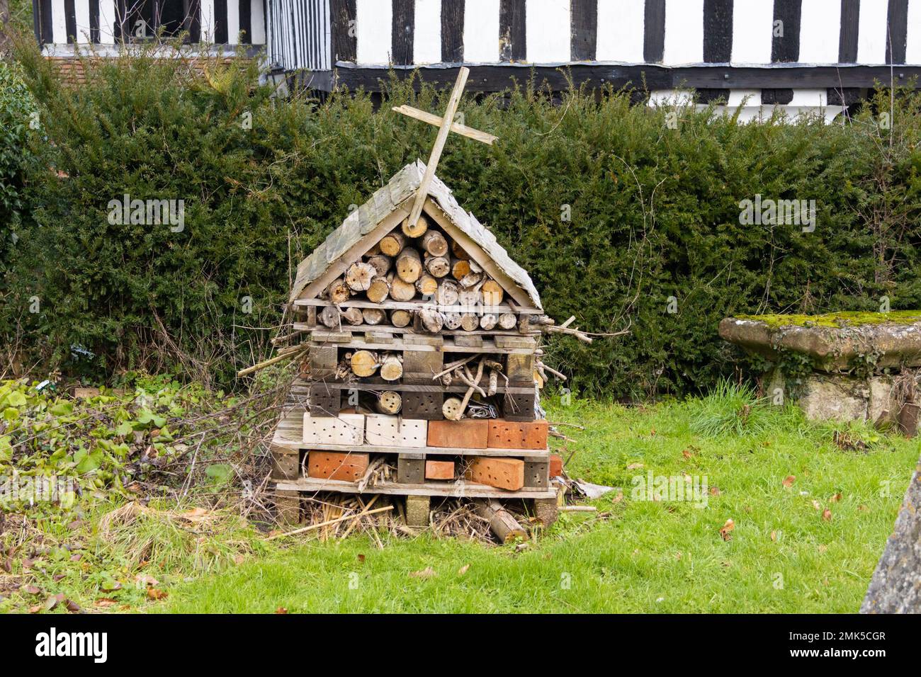 Bug insetto hotel nel terreno della chiesa con croce, lenham, kent, regno unito Foto Stock