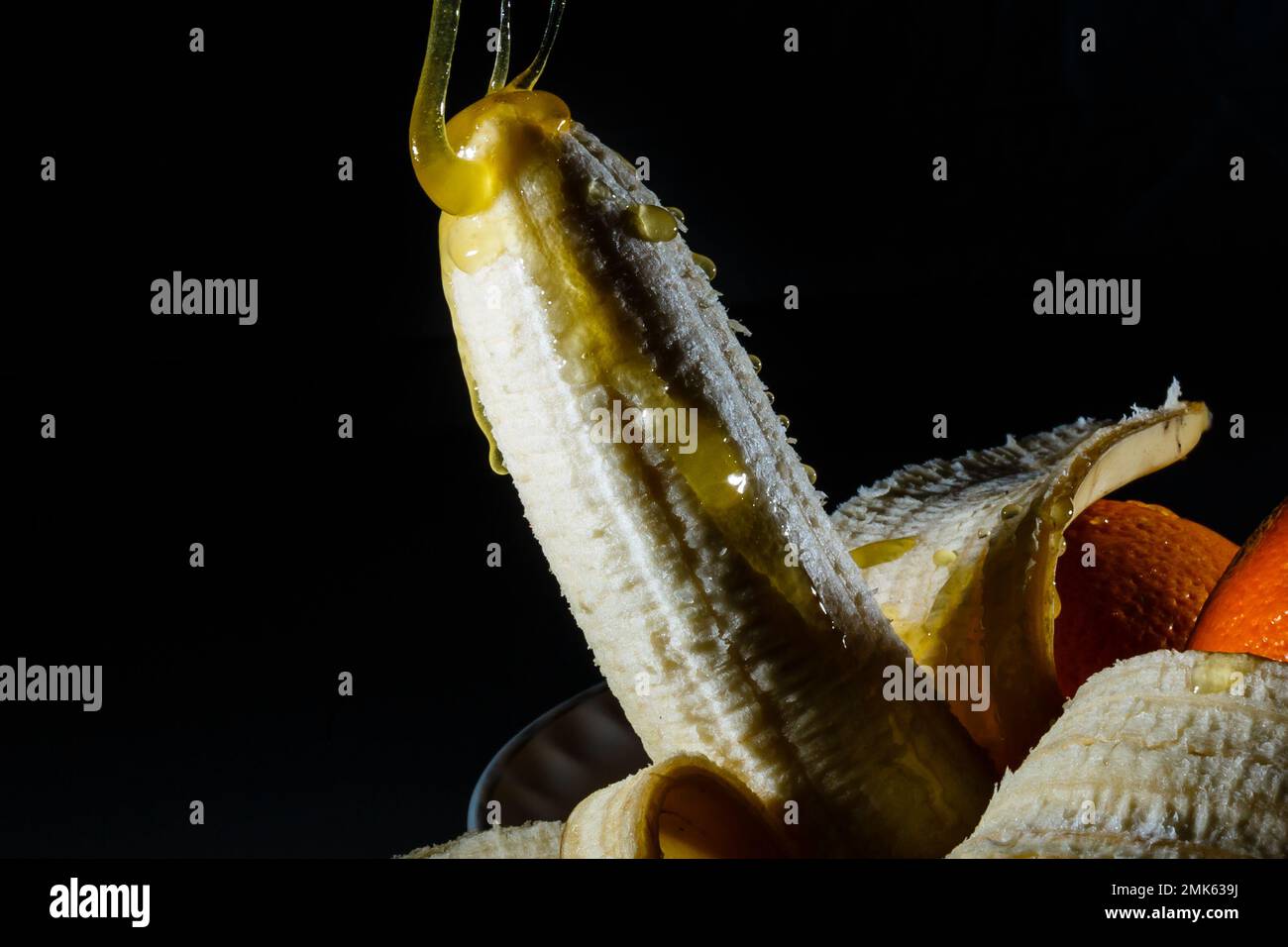 Banana ricoperta con salsa di cioccolato e panna montata su uno sfondo  colorato. Concetto di sesso Foto stock - Alamy