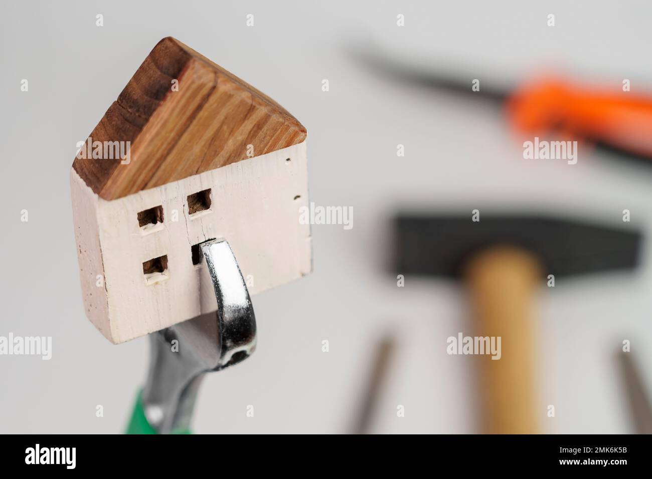 Concetto di miglioramento domestico. Modello di casa in chiave con utensili in sfocatura Foto Stock