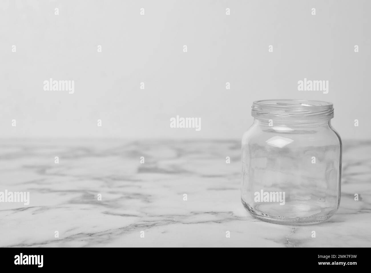 Vaso di vetro vuoto su tavolo in marmo bianco, spazio per testo Foto Stock