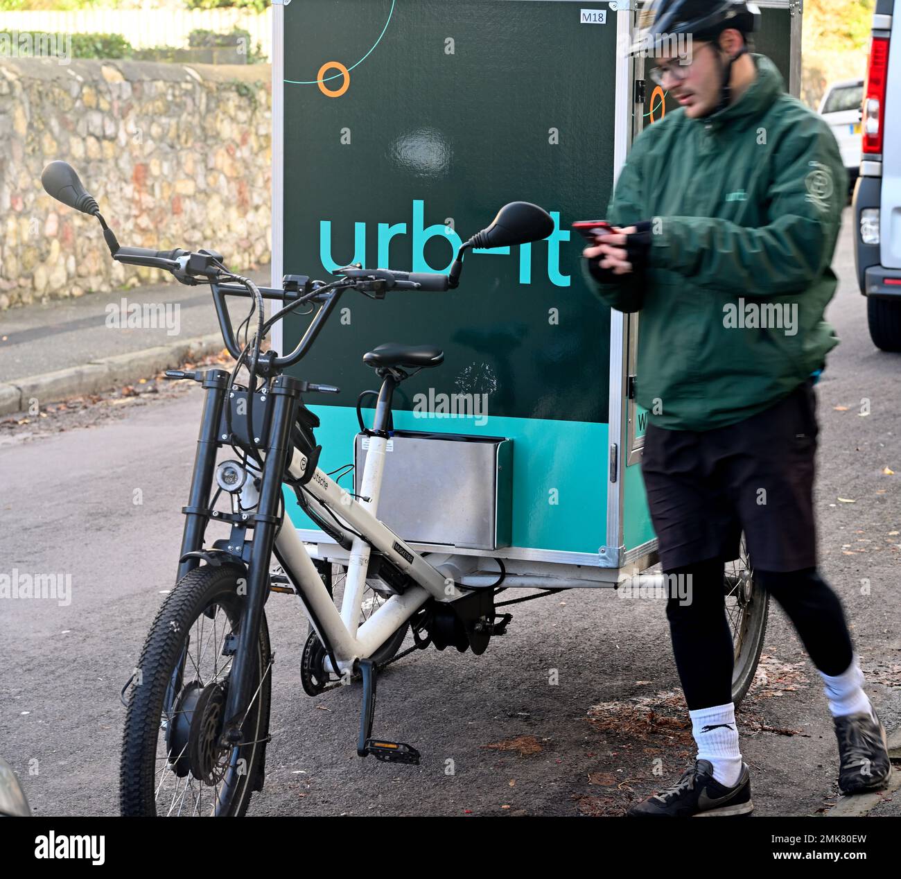 Bici da carico e ciclista utilizzati per la consegna di pacchi con corriere ciclistico urb-IT, Inghilterra Foto Stock