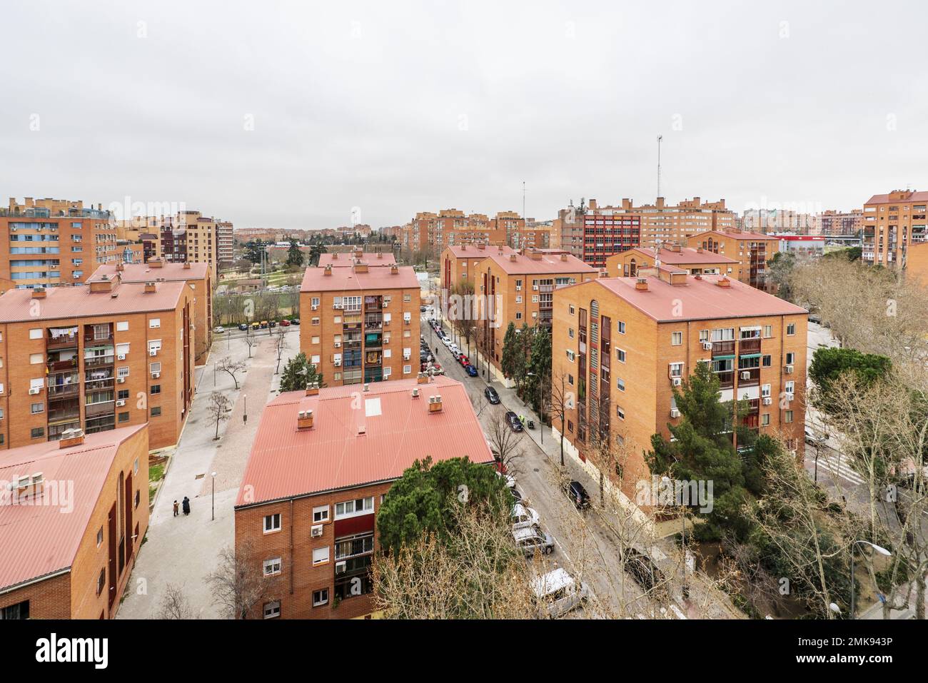 Edifici di quartiere con facciate in mattoni con tetti in argilla e alberi in aree comuni Foto Stock