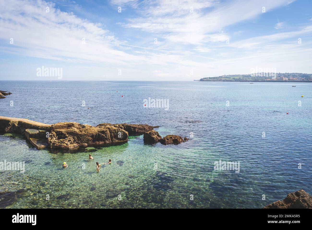Vista sulle persone che nuotano di fronte al Club Astur de Regatas in una giornata estiva a Gijon, Spagna Foto Stock
