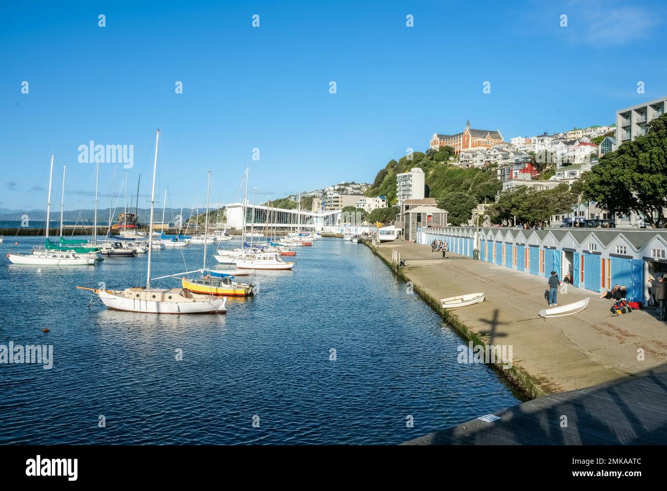 Wellington Nuova Zelanda - Ottobre 3 2010; capannoni delle barche di Oriental Bay e lungomare. Con lo storico Monastero di St Gerard sullo skyline. Foto Stock