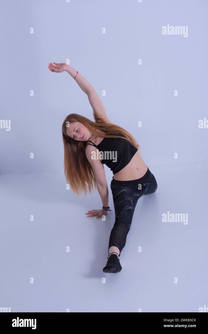 giovane donna bionda con lunghi capelli che formano figure e pilates ginnastica pone fotografia di felicità Foto Stock