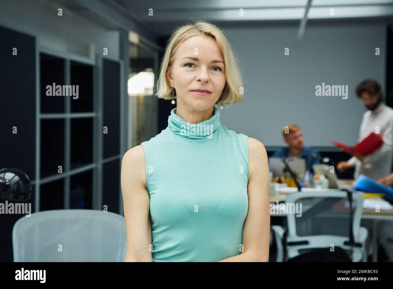 Uomo d'affari caucasico sicuro guardando la macchina fotografica in piedi in ufficio. Persone anziane sul luogo di lavoro Foto Stock