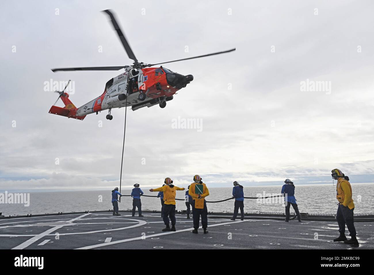 A Coast Guard Air Station Kodiak MH-60 Jayhawk elicottero aircrew e Coast Guard Cutter Healy (WAGB 20) membri dell'equipaggio condurre un elicottero in-flight Refuel (HIFR) in Kotzebue Sound, Alaska, 7 settembre 2022. La formazione viene condotta regolarmente per mantenere le qualifiche degli equipaggi a bordo di entrambi i beni e mantenere la competenza in una varietà di tecniche. Foto Stock