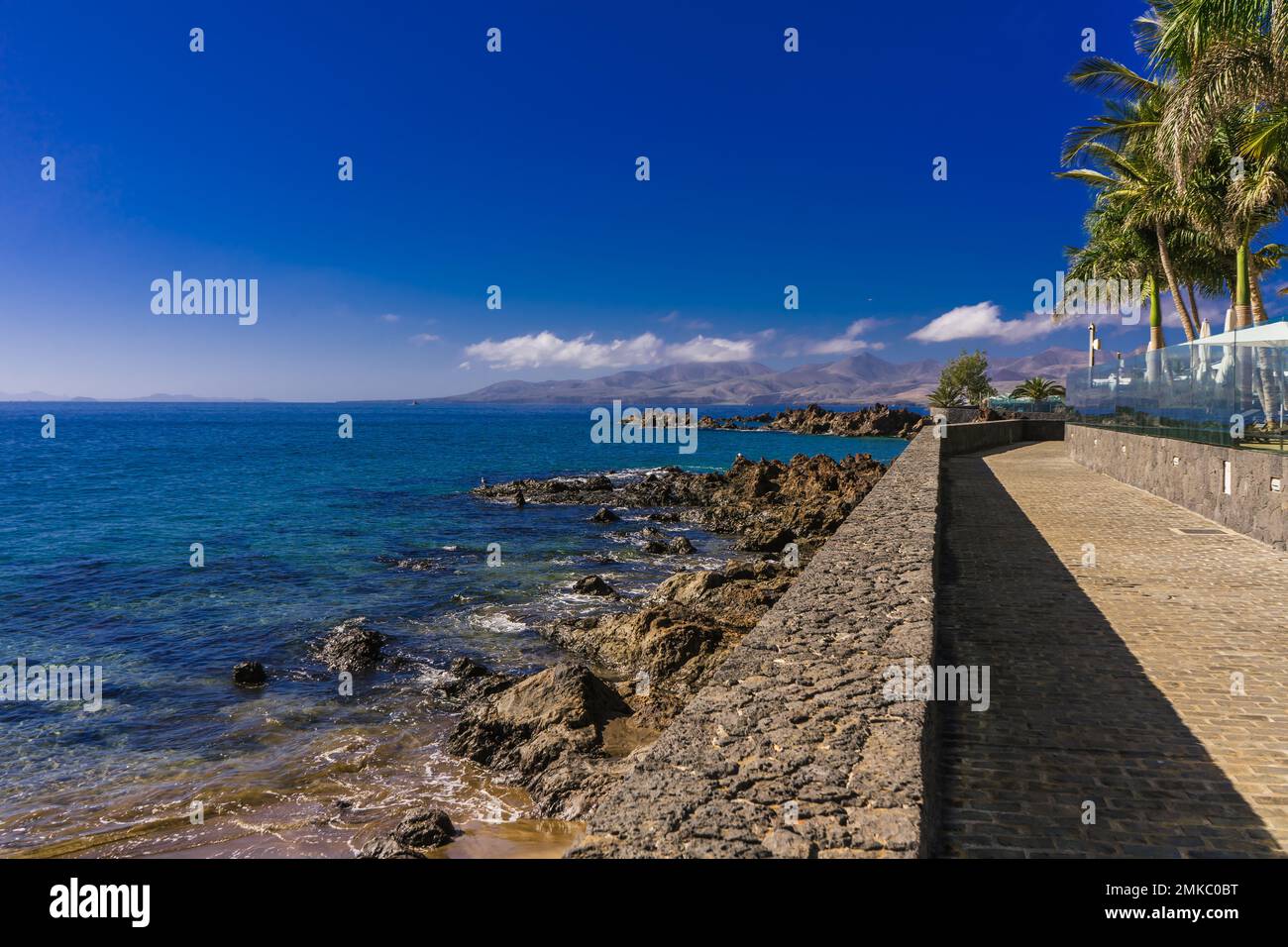 Guardando a sud dalla passeggiata a Puerto del Carmen a Lanzarote. Foto Stock