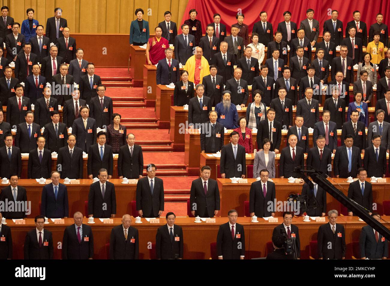 China's top leaders, including Chinese President Xi Jinping, center in second row, stand for the national anthem during the opening session of the Chinese People's Political Consultative Conference in Beijing's Great Hall of the People, Sunday, March 3, 2019. (AP Photo/Ng Han Guan) Foto Stock