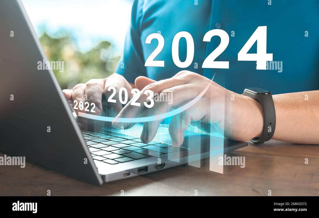 2024 anno nuovo. Persona aziendale che utilizza un notebook con grafico di crescita ologramma. Successo aziendale e crescita degli investimenti in 2024 anni. Tecnologia finanziaria aziendale Foto Stock