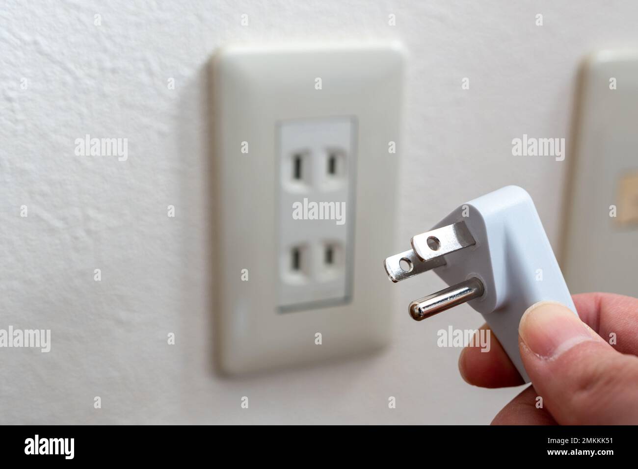 Una presa a muro giapponese senza morsetto di messa a terra. presa di alimentazione a 3 pin tenuta a mano. Foto Stock