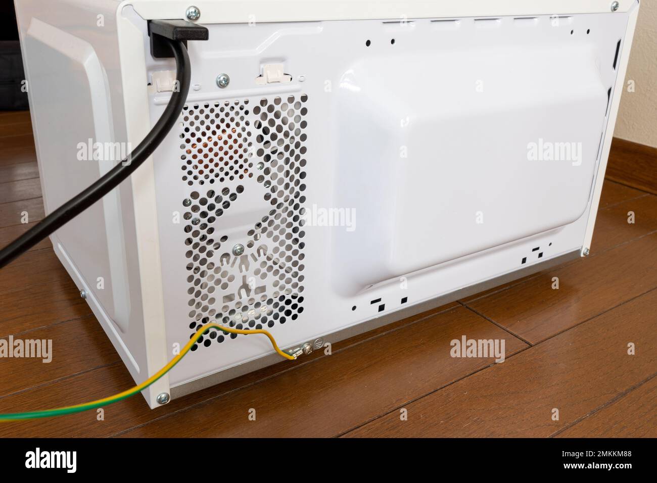 Cavo di messa a terra dietro un forno a microonde modello giapponese. Foto Stock