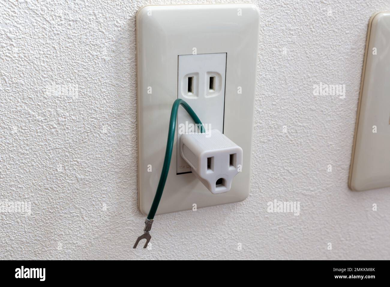 Una spina per adattatore da viaggio sulla presa elettrica giapponese nella stanza. Foto Stock