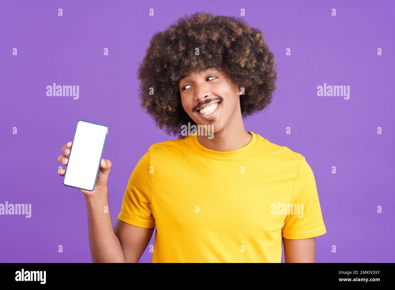 Uomo africano sorridente che tiene un cellulare con uno schermo vuoto Foto Stock