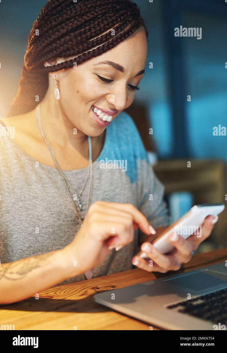 Contrassegnare un'attività come completata. una giovane donna che invia un sms mentre lavora tardi nel suo ufficio. Foto Stock