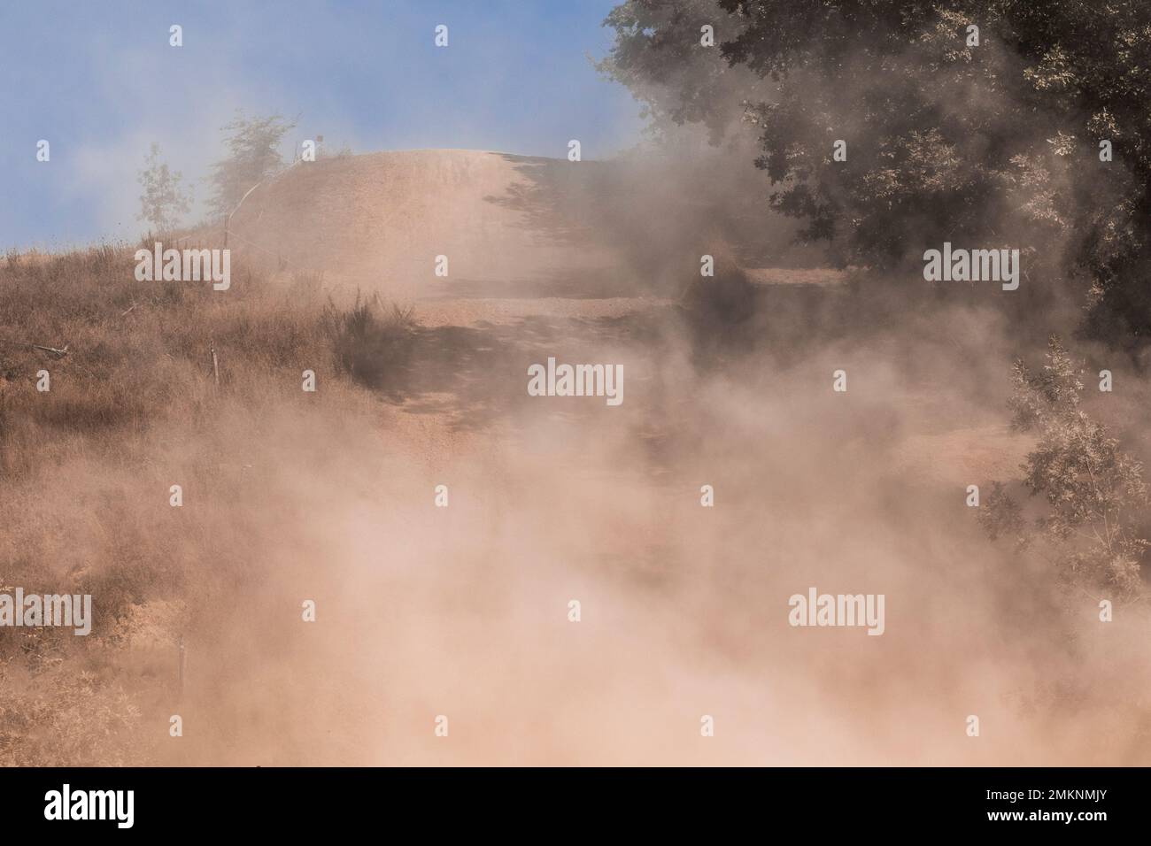 Una grande tempesta di polvere. Polvere e sabbia che scorrono nell'aria su una strada di ghiaia. Concetto di eventi meteorologici estremi, gare rally e fuoristrada. Angolo basso vi Foto Stock