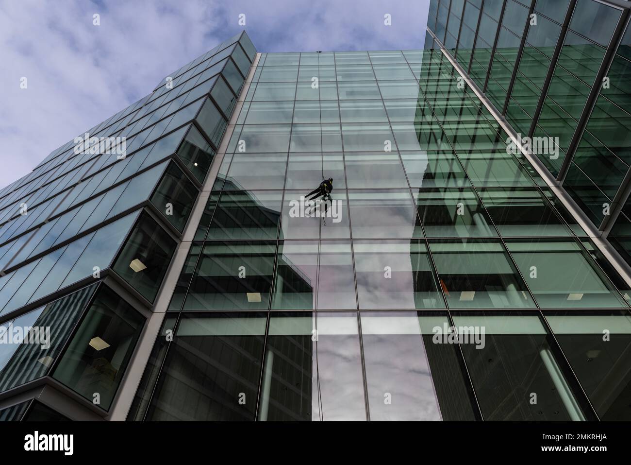 I pulitori per la discesa puliscono i segni dalle finestre di vetro di un alto edificio commerciale di uffici a Victoria, nel centro di Londra, Inghilterra, Regno Unito Foto Stock