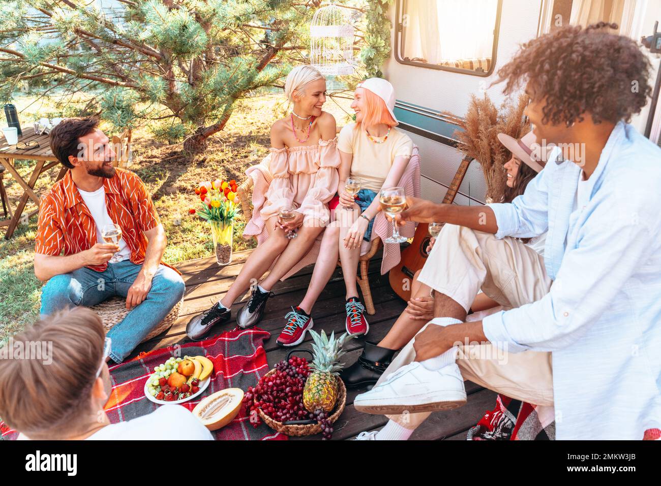 Gruppo di amici hanno un picnic con un camper in una giornata calda Foto Stock