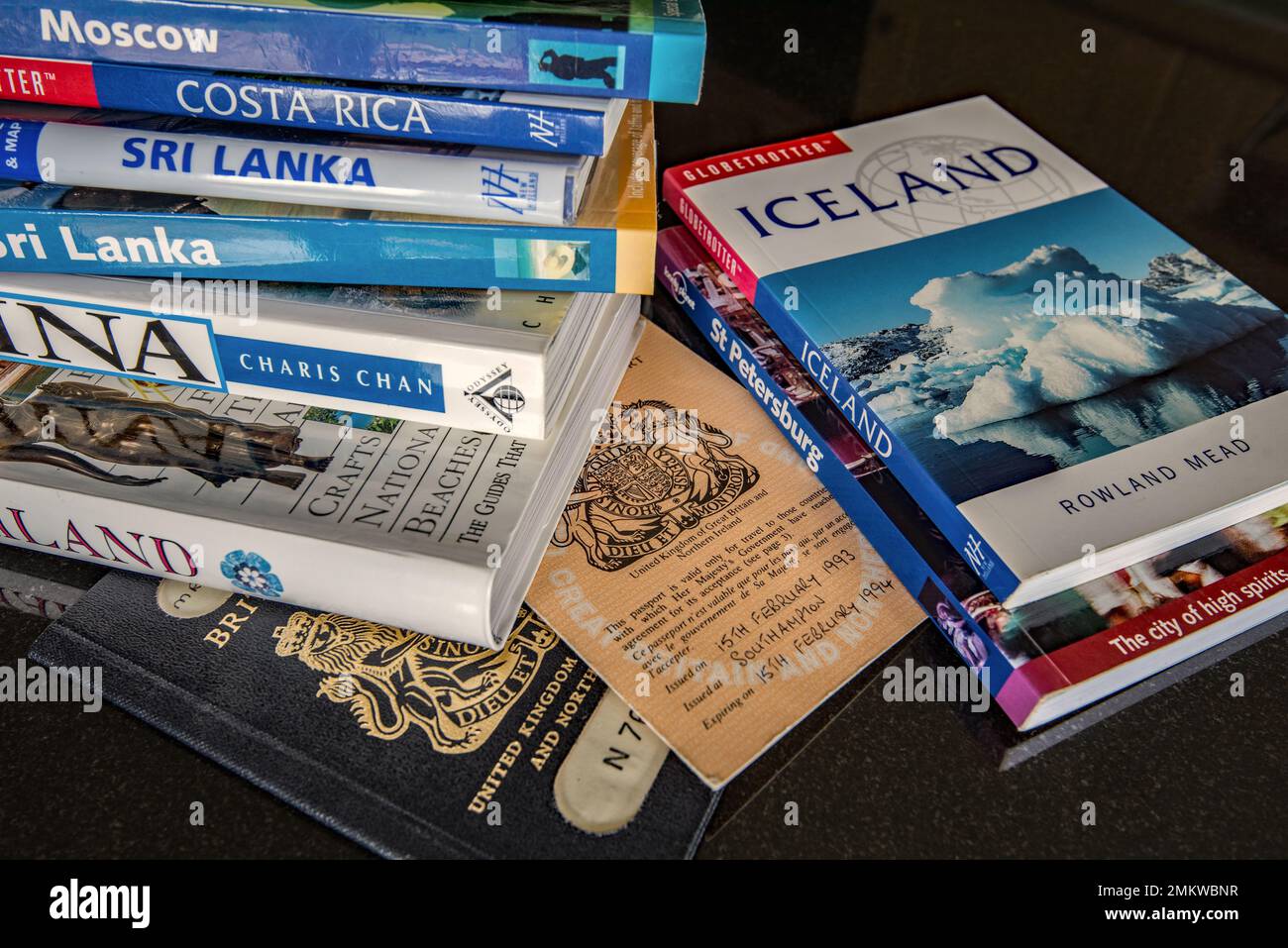 Passaporti inglesi di vecchio stile e un certo numero di guide o libri di informazioni di viaggio. Include Cina Thailandia Islanda Sri Lanka Costa Rica Mosca ecc Foto Stock