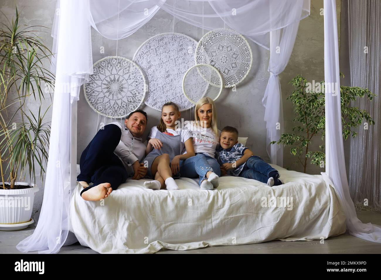 Divertente famiglia attiva di giovani genitori adulti e bambini piccoli carini che giocano insieme nel soggiorno interno, spensierati bambini piccoli con mamma papà che hanno Foto Stock