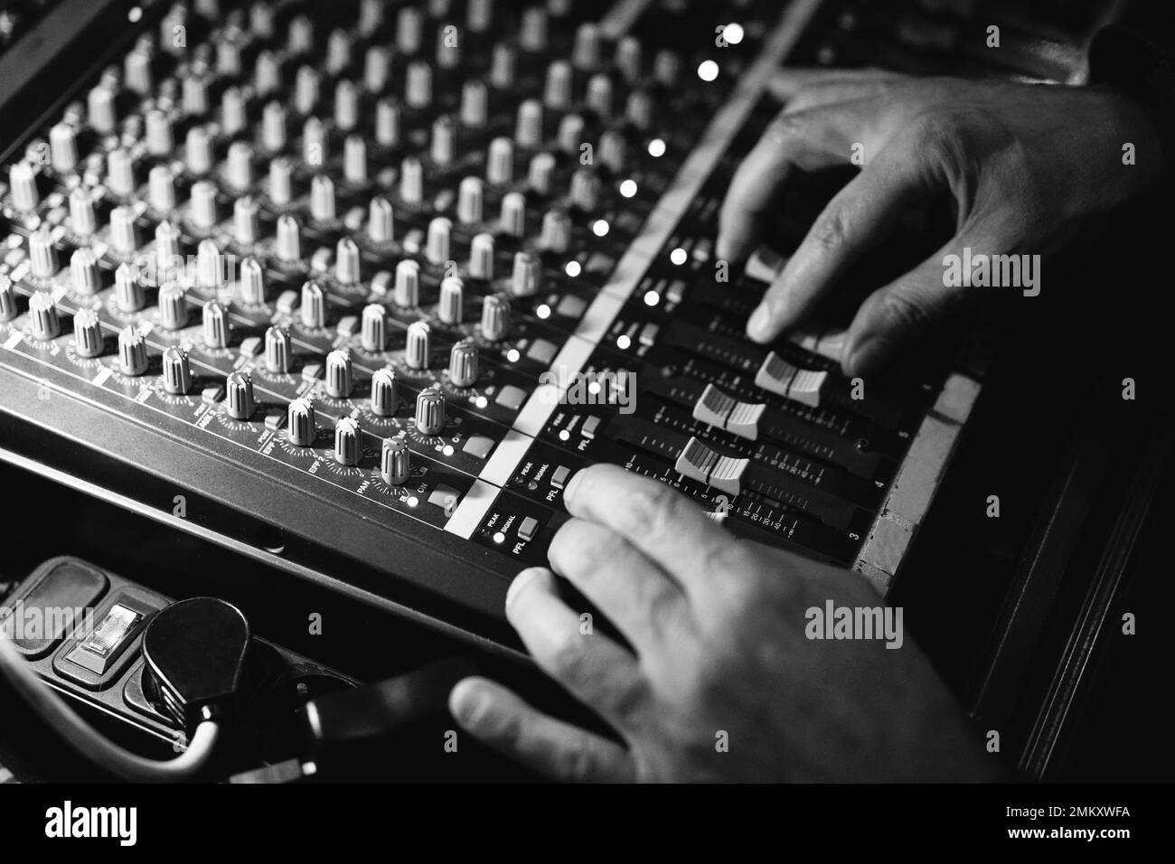 l'ingegnere del suono lavora alla console di mixaggio mescolando la composizione musicale sulla registrazione Foto Stock