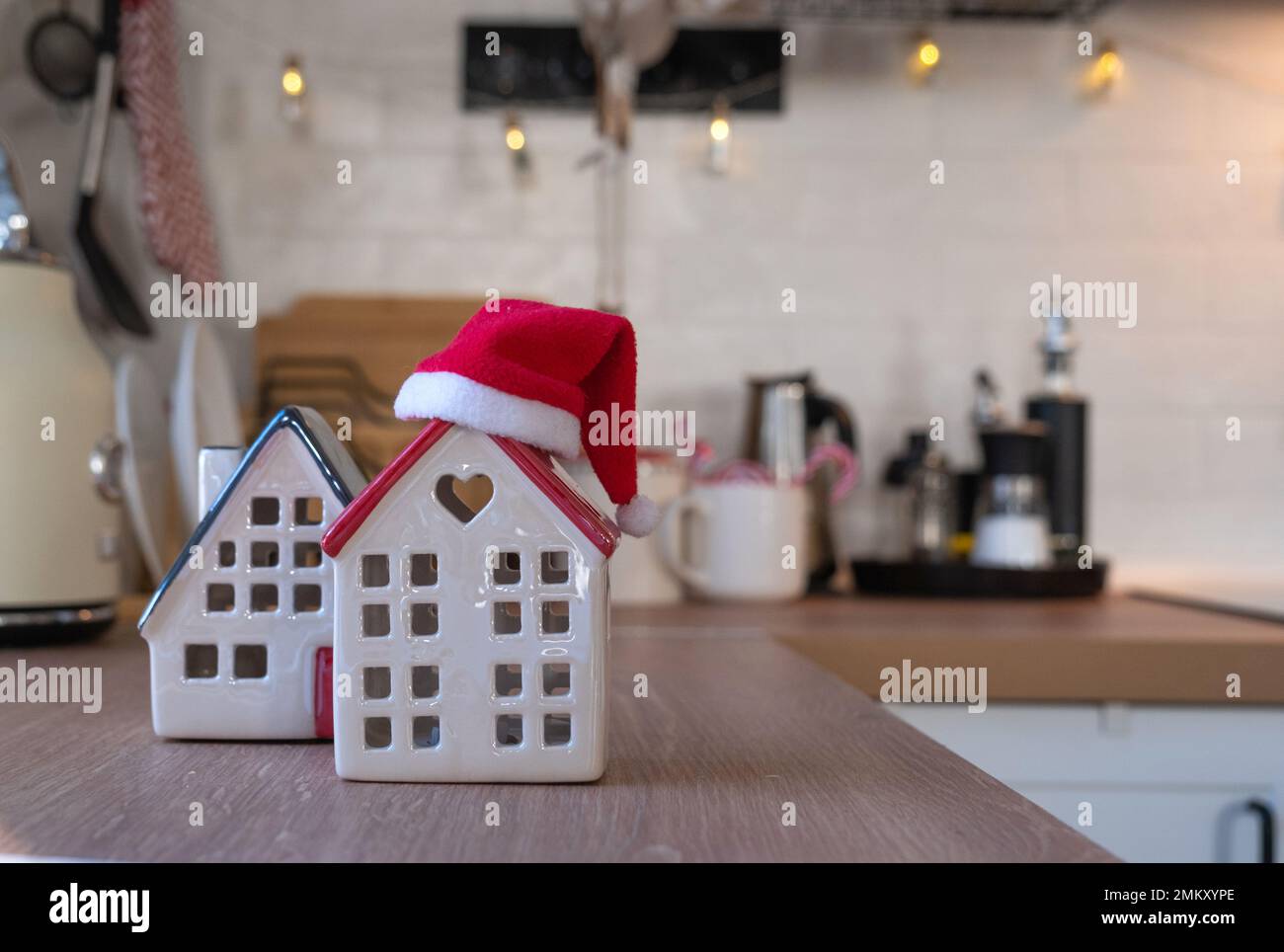 Decorazione della cucina di Natale - preparazione per una vacanza in famiglia, luce fata, albero di Natale, ornamento rosso, cervo divertente su armadi, stufa. Umore del celebrato Foto Stock