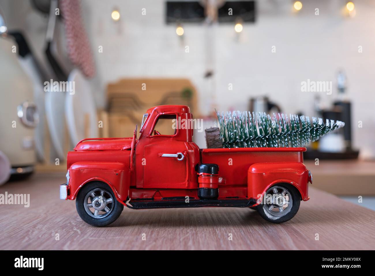 Una macchina rossa retrò con un albero di Natale decora la cucina festosa per Natale. Arredamento per la casa, atmosfera festiva, Capodanno Foto Stock
