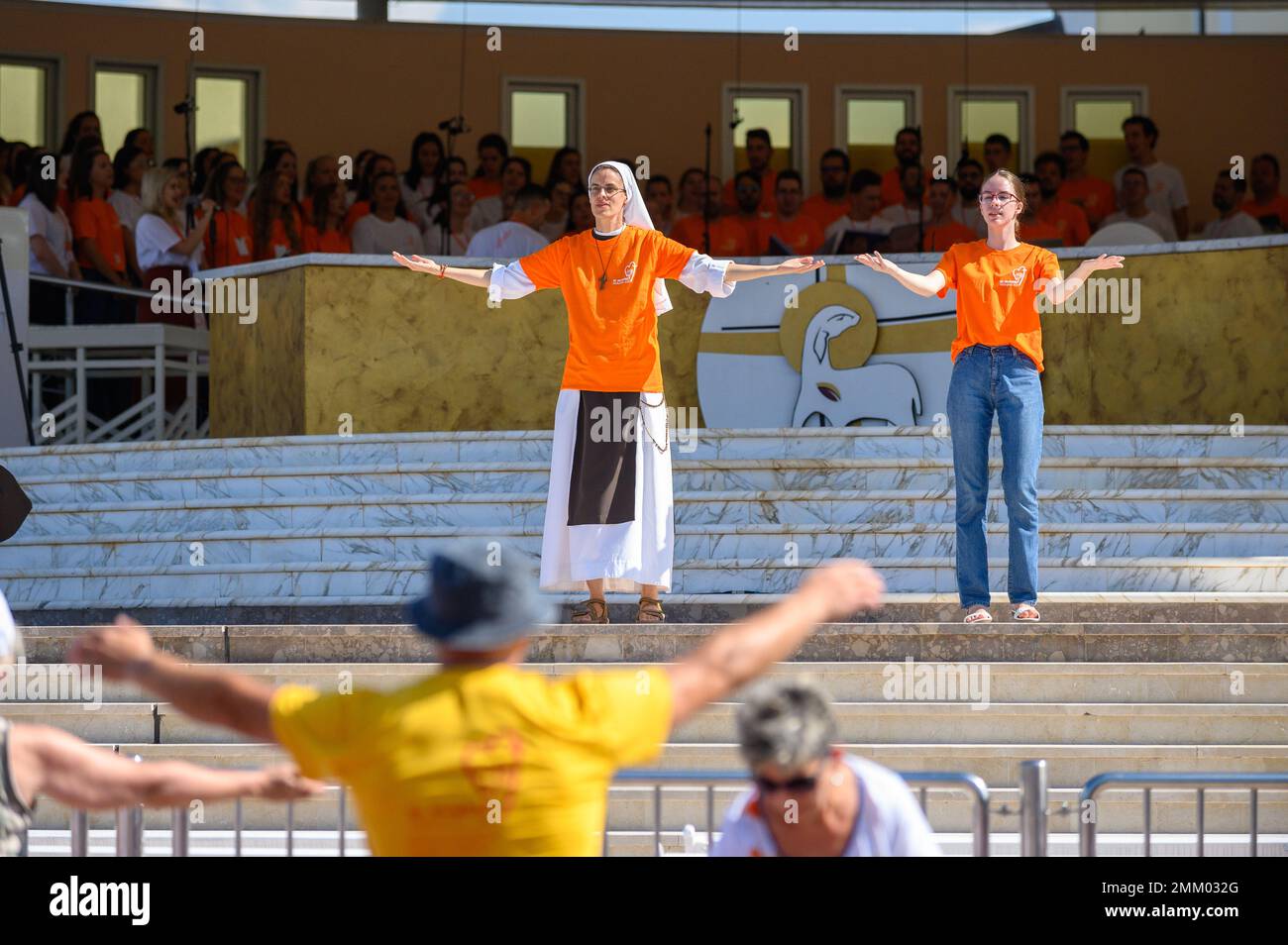 Volontari che mostrano movimenti di mani e corpo per canzoni cristiane e danze al Mladifest 2021, il festival della gioventù, a Medjugorje. Foto Stock