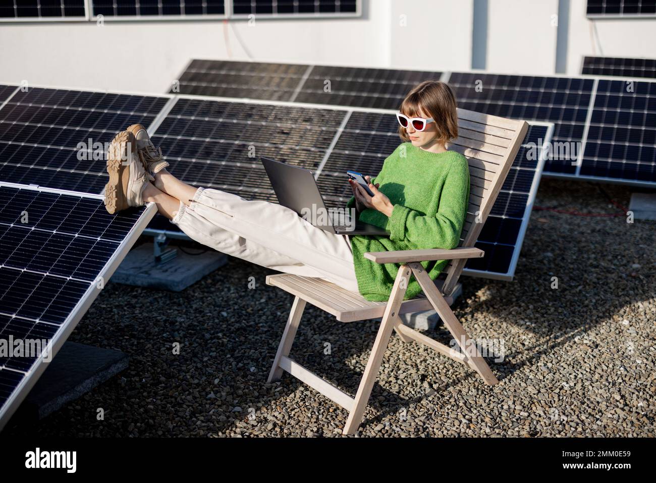 Donna lavora su un tetto con una stazione solare Foto Stock