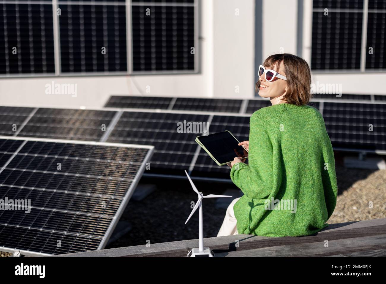 Donna monitora la produzione di energia dalla centrale solare con un tablet digitale Foto Stock