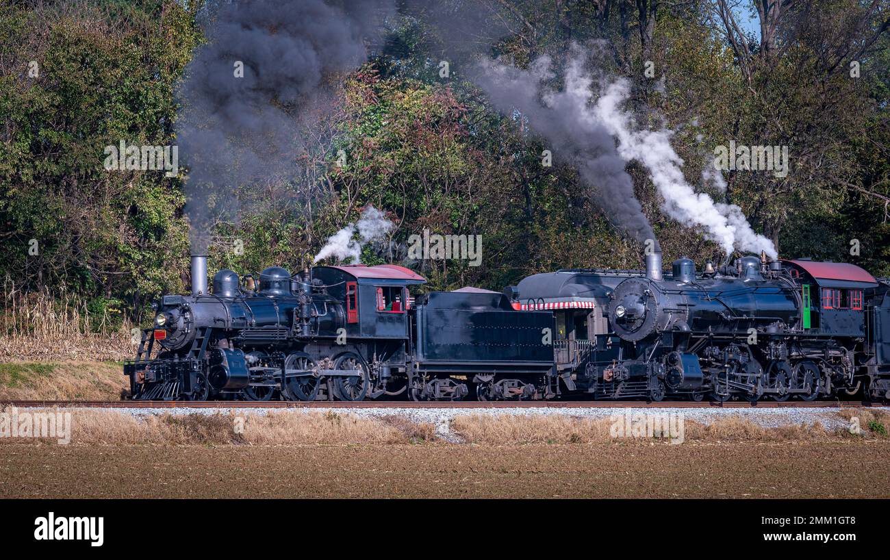 Una veduta di due motori a vapore, uno soffiante di fumo e uno a vapore che  tirano avanti l'altro in un giorno di sole Foto stock - Alamy