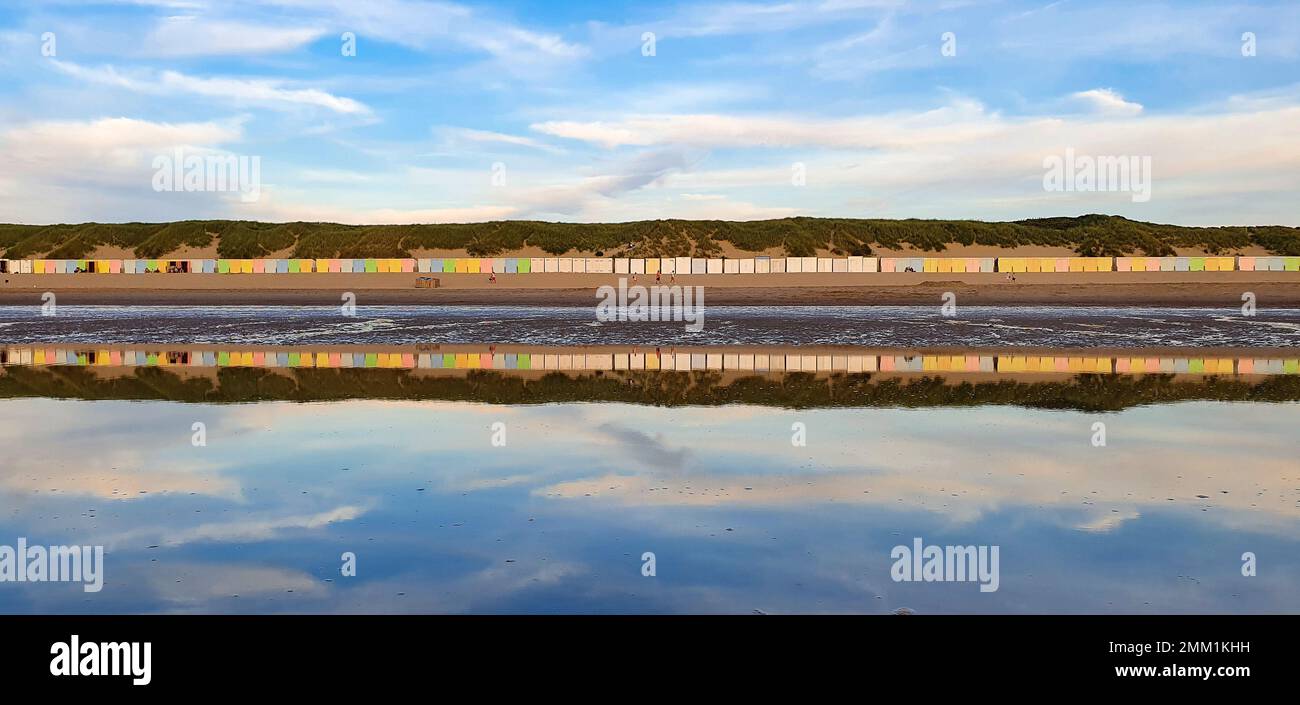 Case sulla spiaggia colorate di sera di umore e riflessione in acqua sulla costa olandese Foto Stock