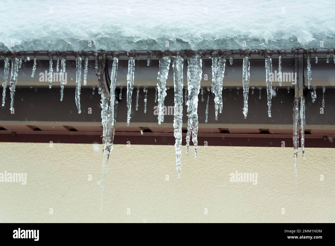 Ci sono tantissimi ghiaccioli appesi dal bordo del tetto, il giorno d'inverno Foto Stock