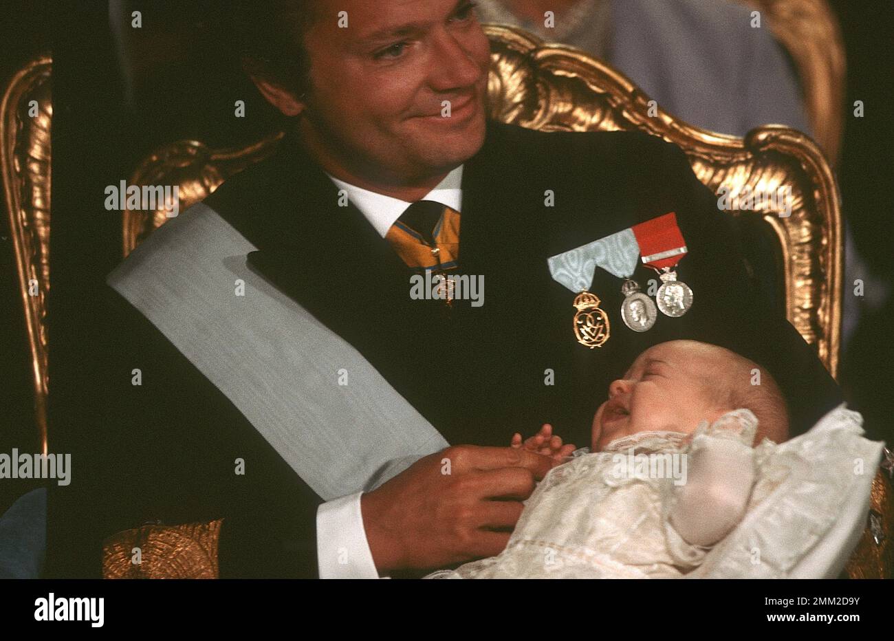 Carl XVI Gustaf, re di Svezia. Nato il 30 aprile 1946. Il re Carlo XVI Gustaf tiene la principessa Madeleine durante il battesimo di lei a Slottskyrkan Stoccolma 31 agosto 1982. Foto Stock
